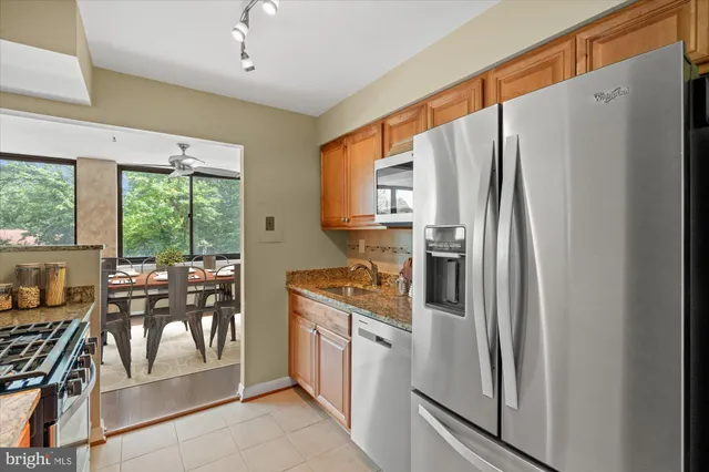 a kitchen with stainless steel appliances granite countertop a refrigerator and a stove