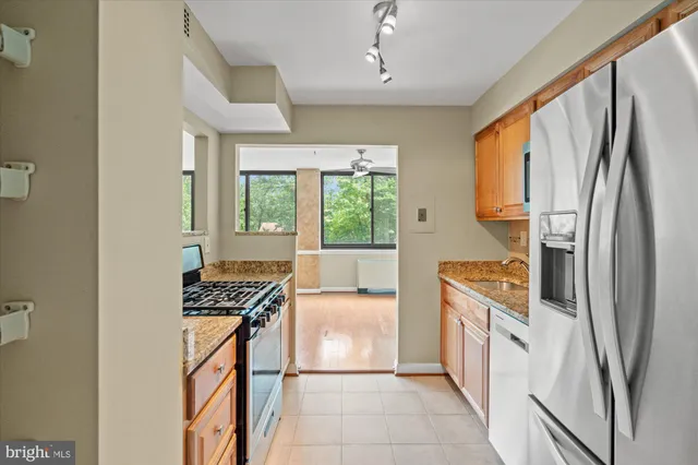 a kitchen with stainless steel appliances granite countertop a refrigerator and a stove