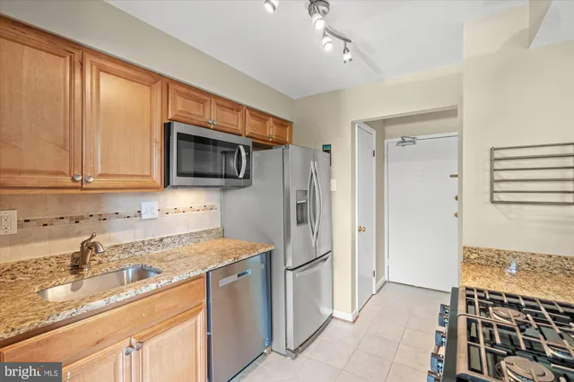 a kitchen with stainless steel appliances granite countertop a refrigerator stove and sink