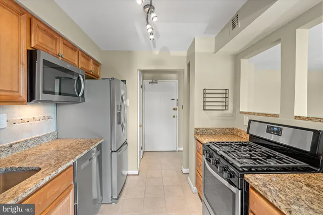 a kitchen with stainless steel appliances granite countertop a stove and a refrigerator