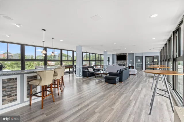 a living room with furniture a flat screen tv and a floor to ceiling window