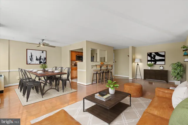 a living room with furniture a rug and a dining table