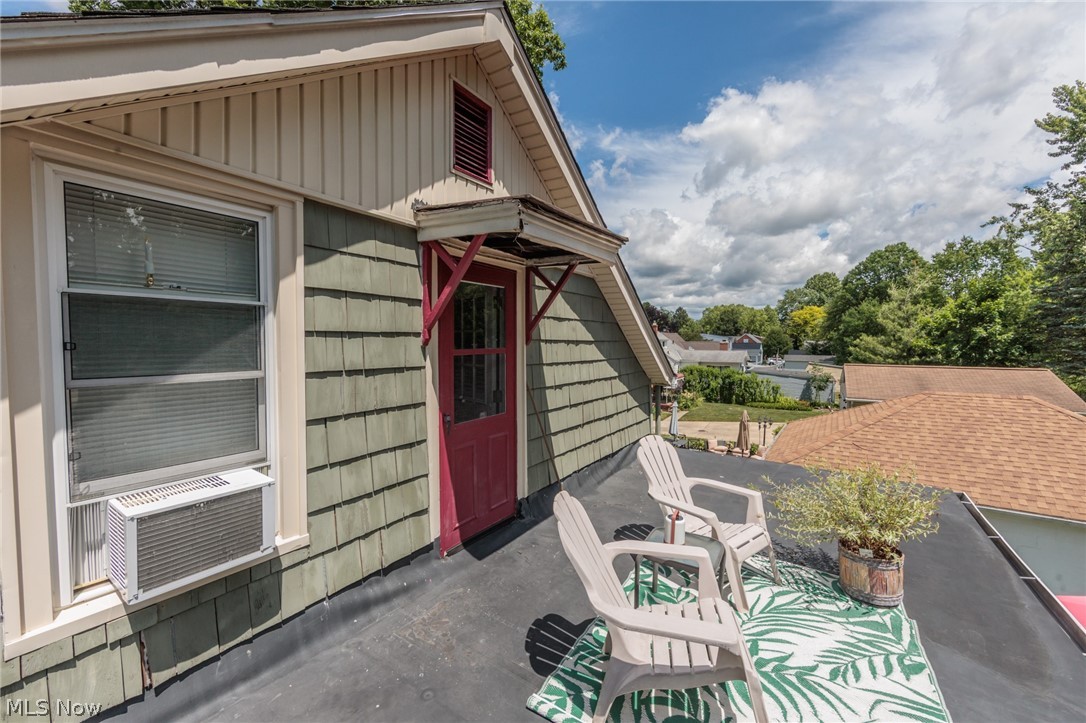 5364 Summit Road Lyndhurst, OH 44124 - Photo 22 of 42 Second-story deck featuring a red entry door, green shingle siding, and a window with trim