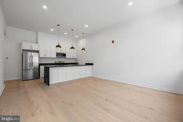 a kitchen with stainless steel appliances kitchen island a refrigerator sink and cabinets