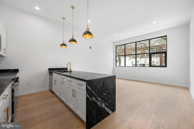 a kitchen with stainless steel appliances kitchen island a refrigerator sink and cabinets