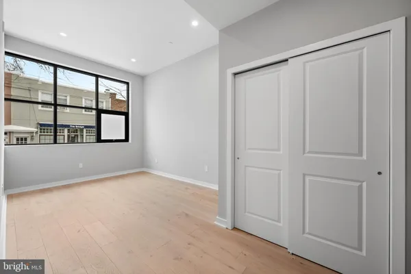 an empty room with windows and closet