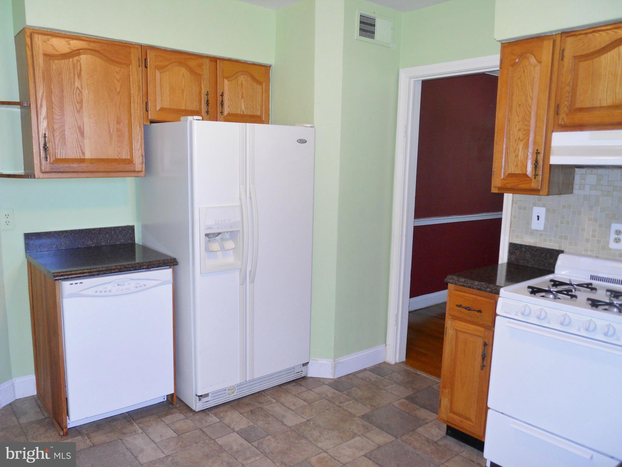7311 Knollwood Road Baltimore, MD 21286 - Photo 8 of 30 a white refrigerator freezer and a stove sitting inside of a kitchen