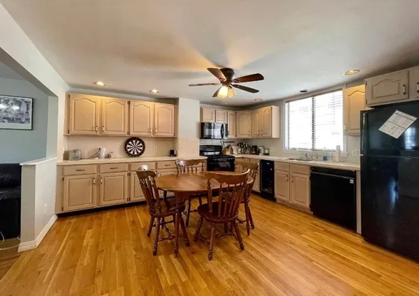 a kitchen with a table chairs a oven a sink dishwasher and cabinets with wooden floor