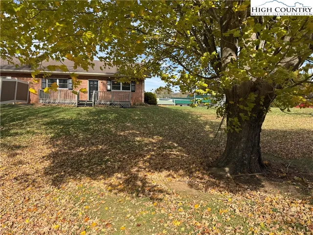 a view of a yard in front of a house with large trees