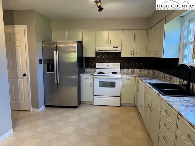 a kitchen with a refrigerator sink and cabinets