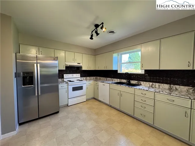 a kitchen with a refrigerator sink and cabinets