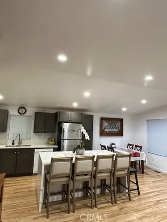 a kitchen with a table chairs refrigerator and cabinets
