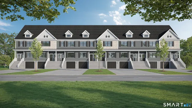 a front view of residential houses with yard and seating space