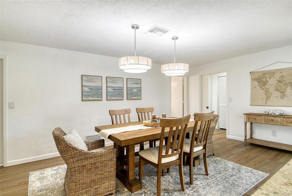 6722 Roxbury Drive Sarasota, FL 34231 - Photo 32 of 87 a dining room with furniture a chandelier and wooden floor