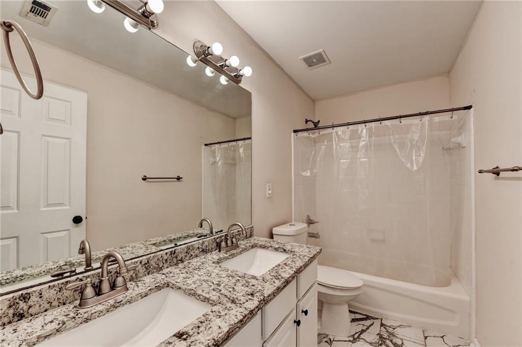 100 Hawnley Trc Northwest Suwanee, GA 30024 - Photo 48 of 58 a bathroom with a granite countertop sink a toilet and a mirror