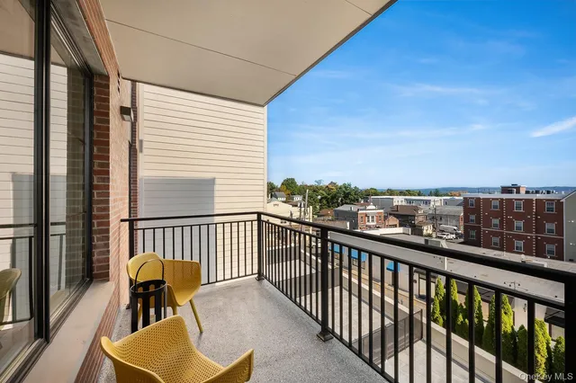 a view of a city from a balcony with furniture