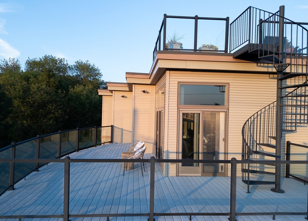 8 Goldfinch Way Ipswich, MA 01938 - Photo 11 of 41 a view of a roof deck with table and chairs with wooden floor and fence
