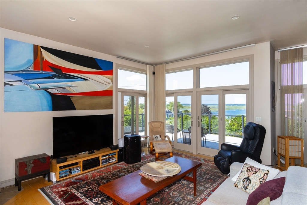 8 Goldfinch Way Ipswich, MA 01938 - Photo 14 of 41 a living room with furniture a flat screen tv and a floor to ceiling window