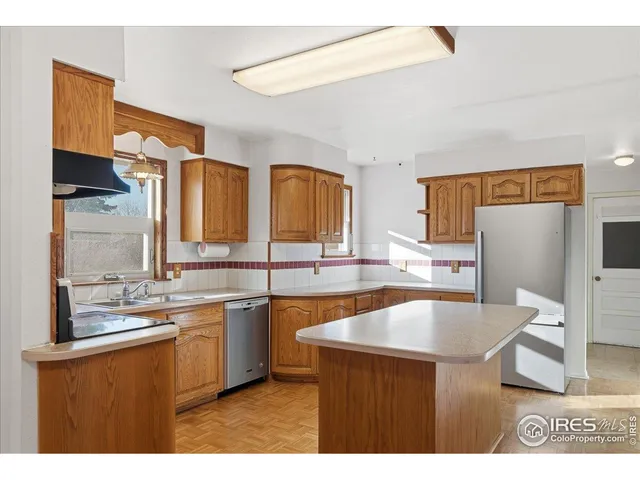 a kitchen with stainless steel appliances granite countertop a sink a stove top oven a counter space and cabinets