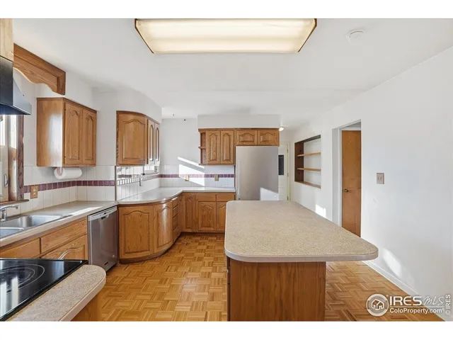 a view of a kitchen with wooden floor and a window