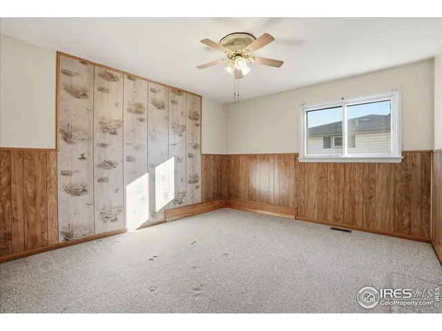 a view of an empty room with a chandelier fan