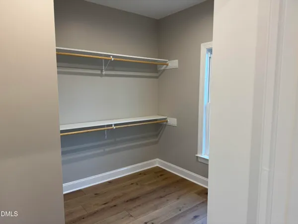 a view of walk in closet with empty racks