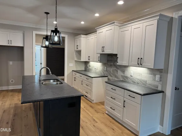 a kitchen with kitchen island granite countertop a sink appliances and cabinets
