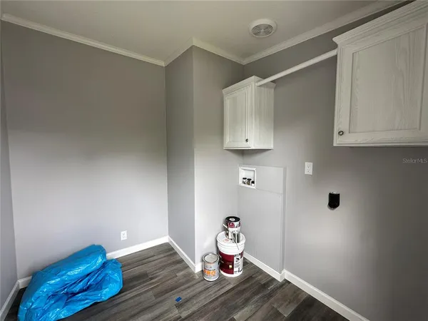 a large white kitchen with a stove a sink dishwasher and a microwave oven with large wooden cabinets