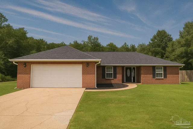 a front view of house with yard and trees in the background