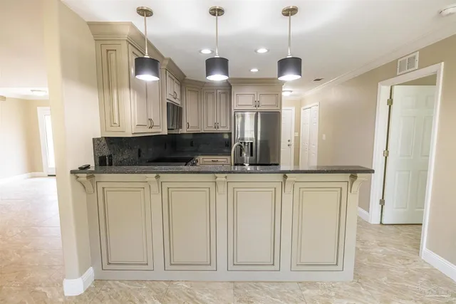 a view of a kitchen with stainless steel appliances granite countertop cabinets and a refrigerator