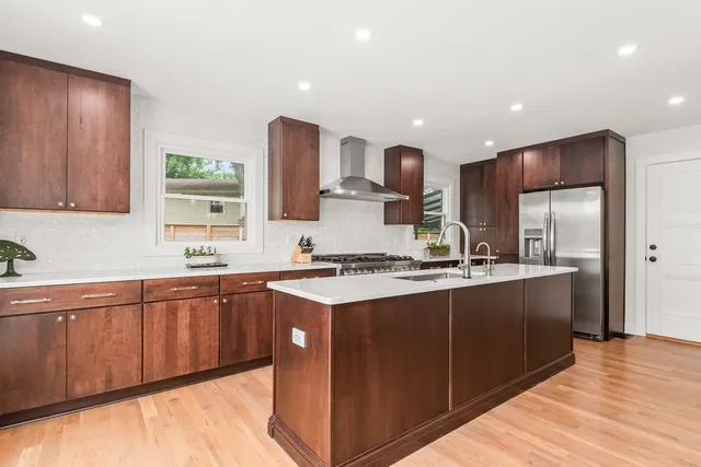 a kitchen with stainless steel appliances granite countertop a sink stove and refrigerator