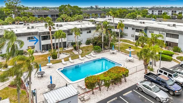 a view of a swimming pool with lawn chairs and plants