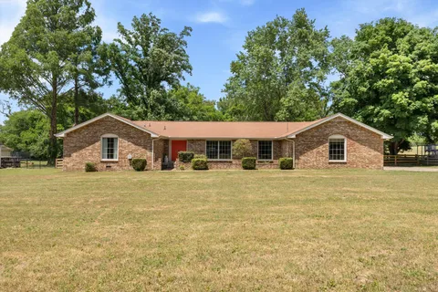 a front view of a house with a yard and trees