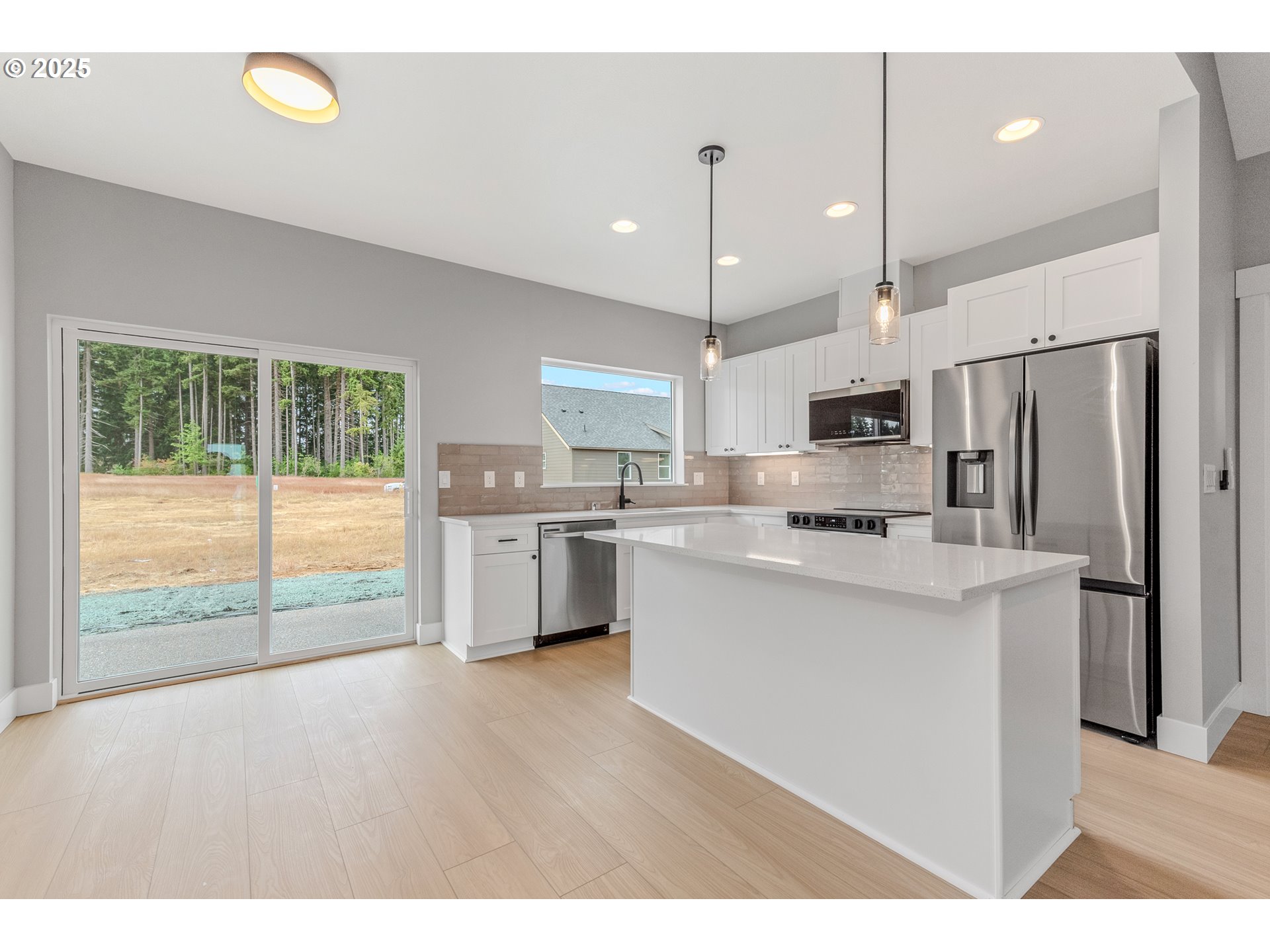 623 Vertex Street Winlock, WA 98596 - Photo 13 of 38 a kitchen with stainless steel appliances kitchen island granite countertop a refrigerator a sink a stove and white cabinets with wooden floor