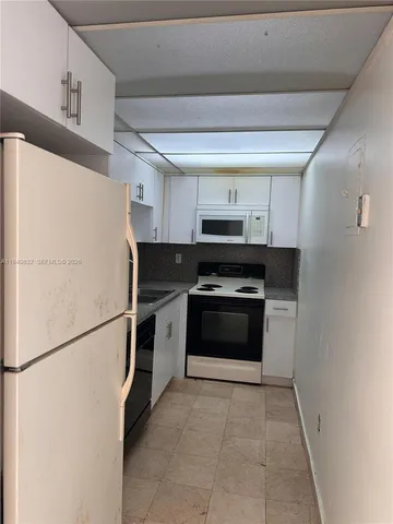 a kitchen with stainless steel appliances a refrigerator sink and white cabinets