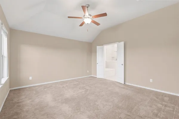 an empty room with closet and a ceiling fan