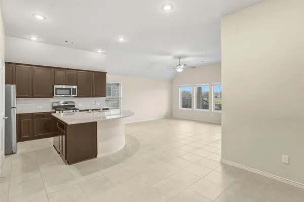 a kitchen with stainless steel appliances a stove top oven a sink a refrigerator and a microwave