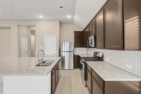 a kitchen with a stove sink and cabinets