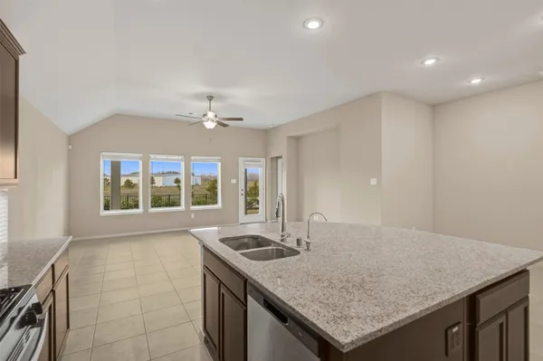 a kitchen with granite countertop a sink and a stove