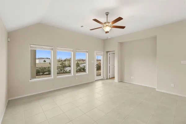 an empty room with windows and fan