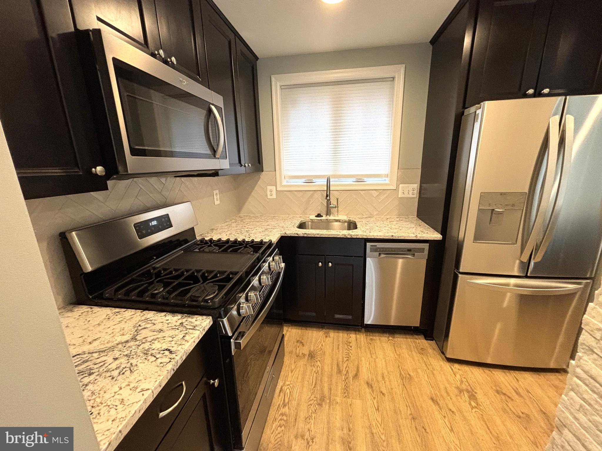 3512 Gunston Road Alexandria, VA 22302 - Photo 7 of 29 a kitchen with granite countertop a refrigerator stove and sink