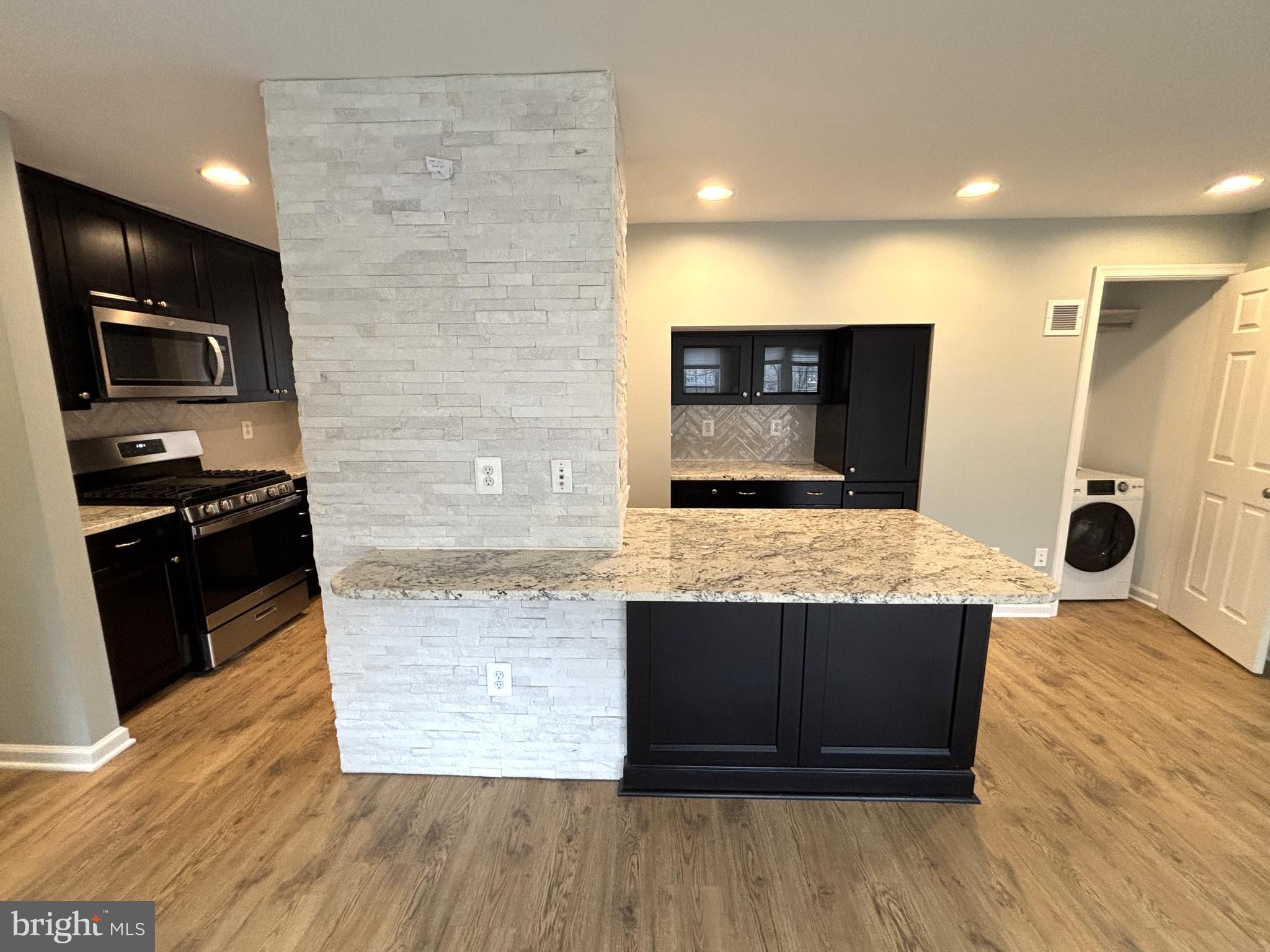 3512 Gunston Road Alexandria, VA 22302 - Photo 29 of 29 a kitchen with stainless steel appliances kitchen island granite countertop a stove a sink and a microwave