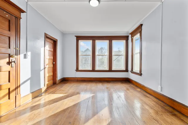 a view of an empty room with glass door and windows