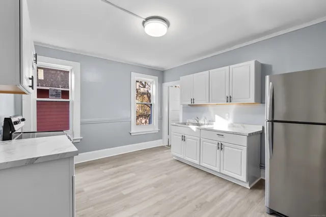 a kitchen with granite countertop a refrigerator sink and cabinets