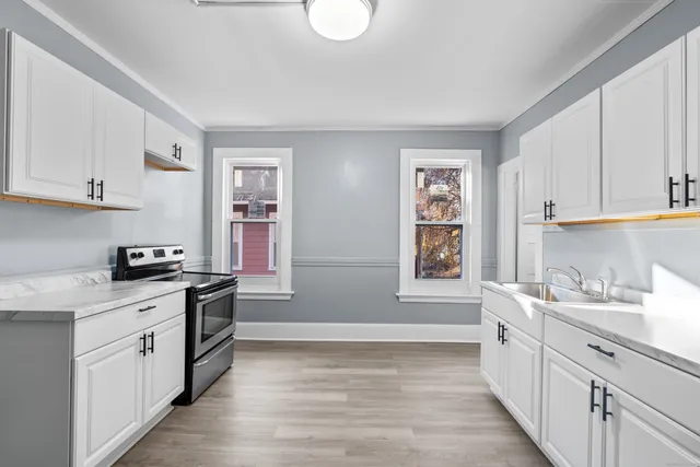 a kitchen with stainless steel appliances granite countertop a sink stove and cabinets