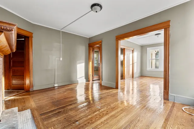 a view of a hallway with wooden floor and glass door