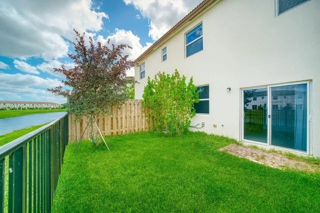 a view of a house with backyard and a tree