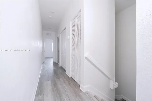 a view of a hallway with wooden floor