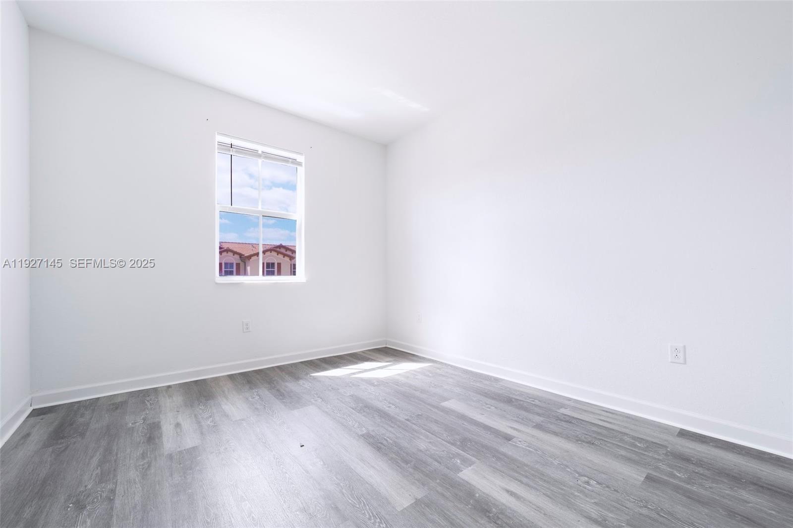 12661 Northwest 23rd Place Miami, FL 33167 - Photo 26 of 34 an empty room with wooden floor and windows