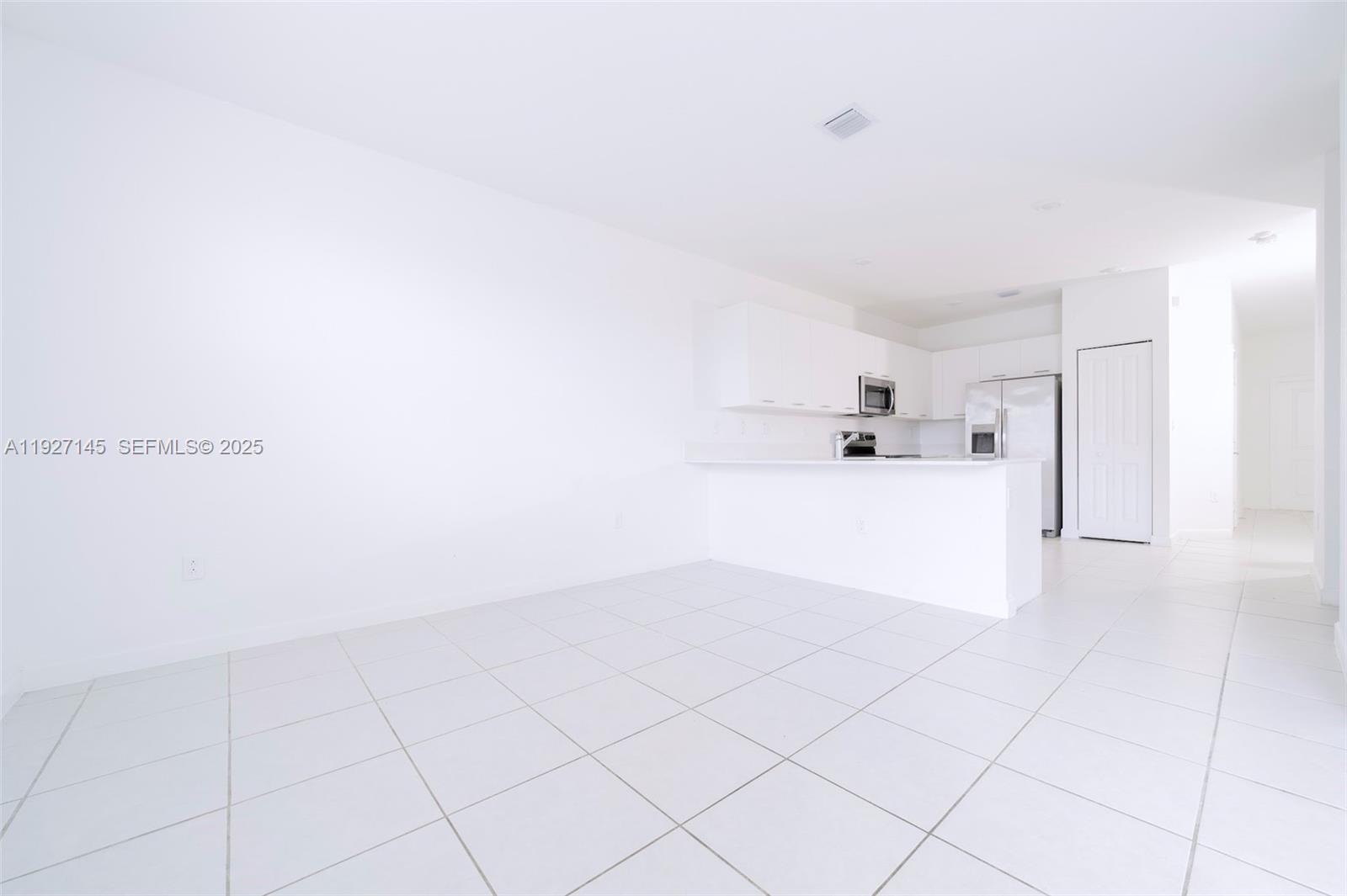 12661 Northwest 23rd Place Miami, FL 33167 - Photo 9 of 34 a view of a kitchen with white cabinets